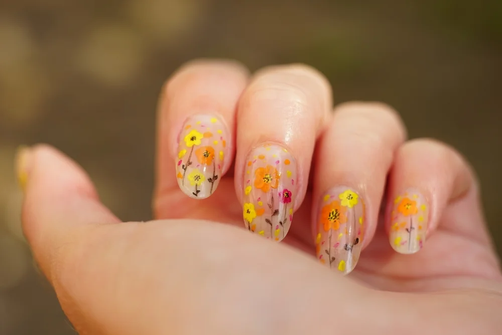Close-up of pastel nail art with glitter and tiny designs